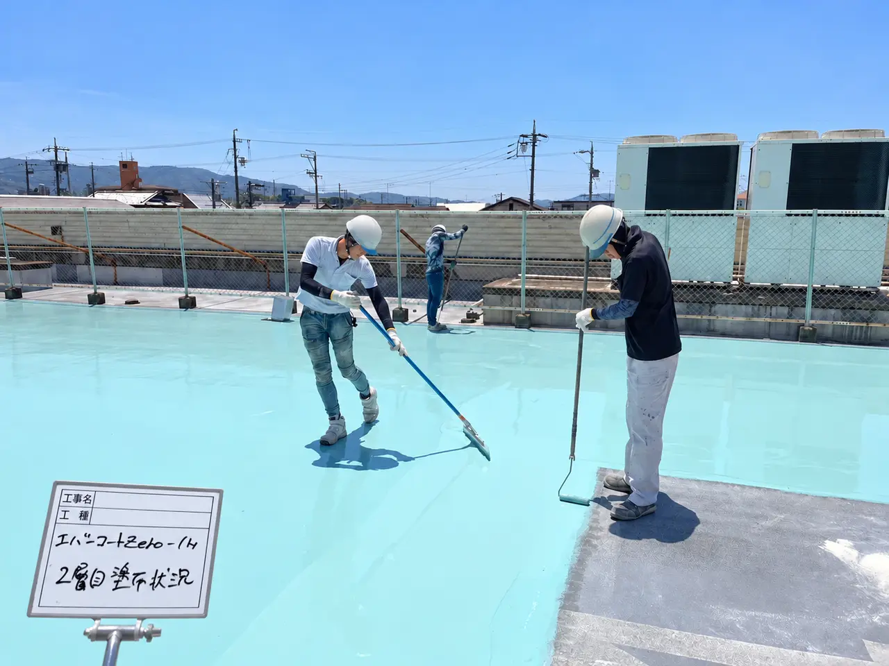 作業員が床面にウレタン2層目を塗り広げる様子